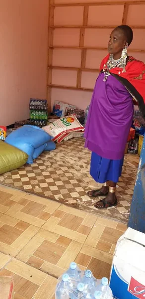 Neema met haar kinderen bij haar nieuwe winkel